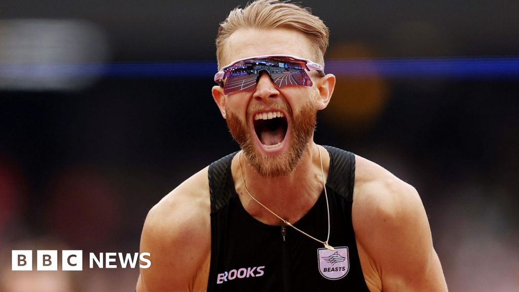 Josh Kerr roars with delighted after breaking the mile record. he has blonde hair and a beared and is wearing a black