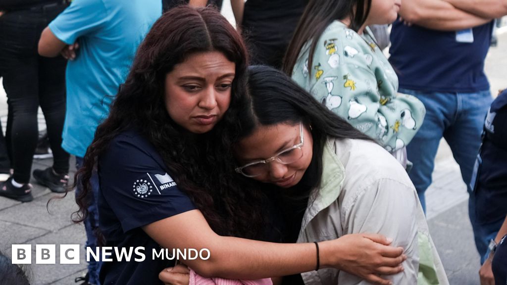 Dos mujeres se abrazan luego de evacuar su lugar de trabajo por un terremoto