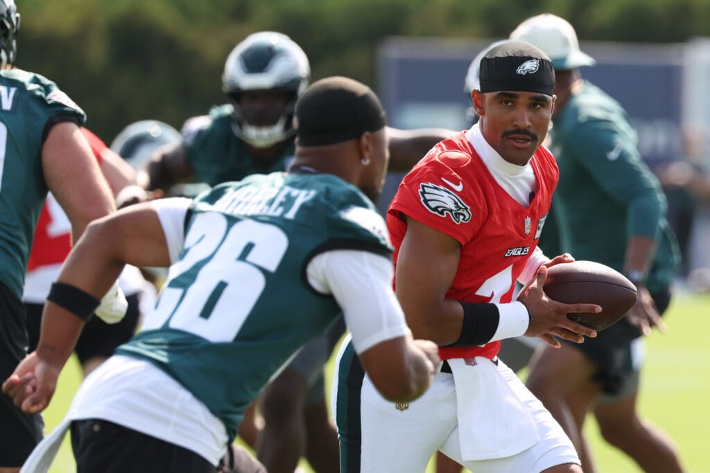 Eagles quarterback Jalen Hurts (1) hands off to running back Saquon Barkley (26) during training camp at Jefferson Health