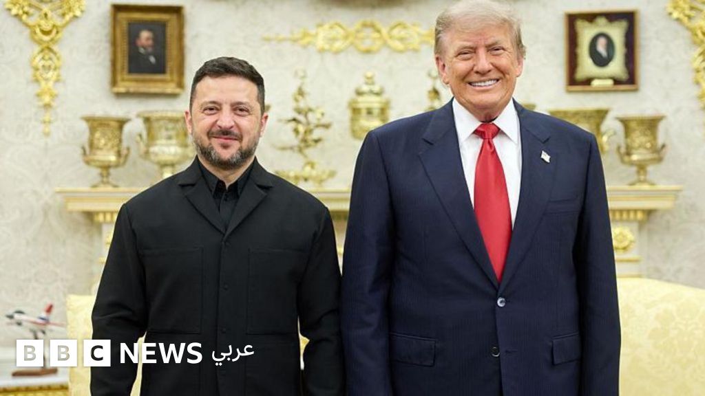 ترامب يرتدي بدلة رسمية كحلية اللون وقميصاً أبيض وربطة عنق يقف في المكتب البيضاوي بجانب زيلينكسي الذي يرتدي قميصاً أسود اللون