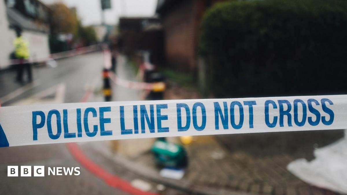 White and blue police cordon tape and the mess on the street in the background, in the place of the crime scene
