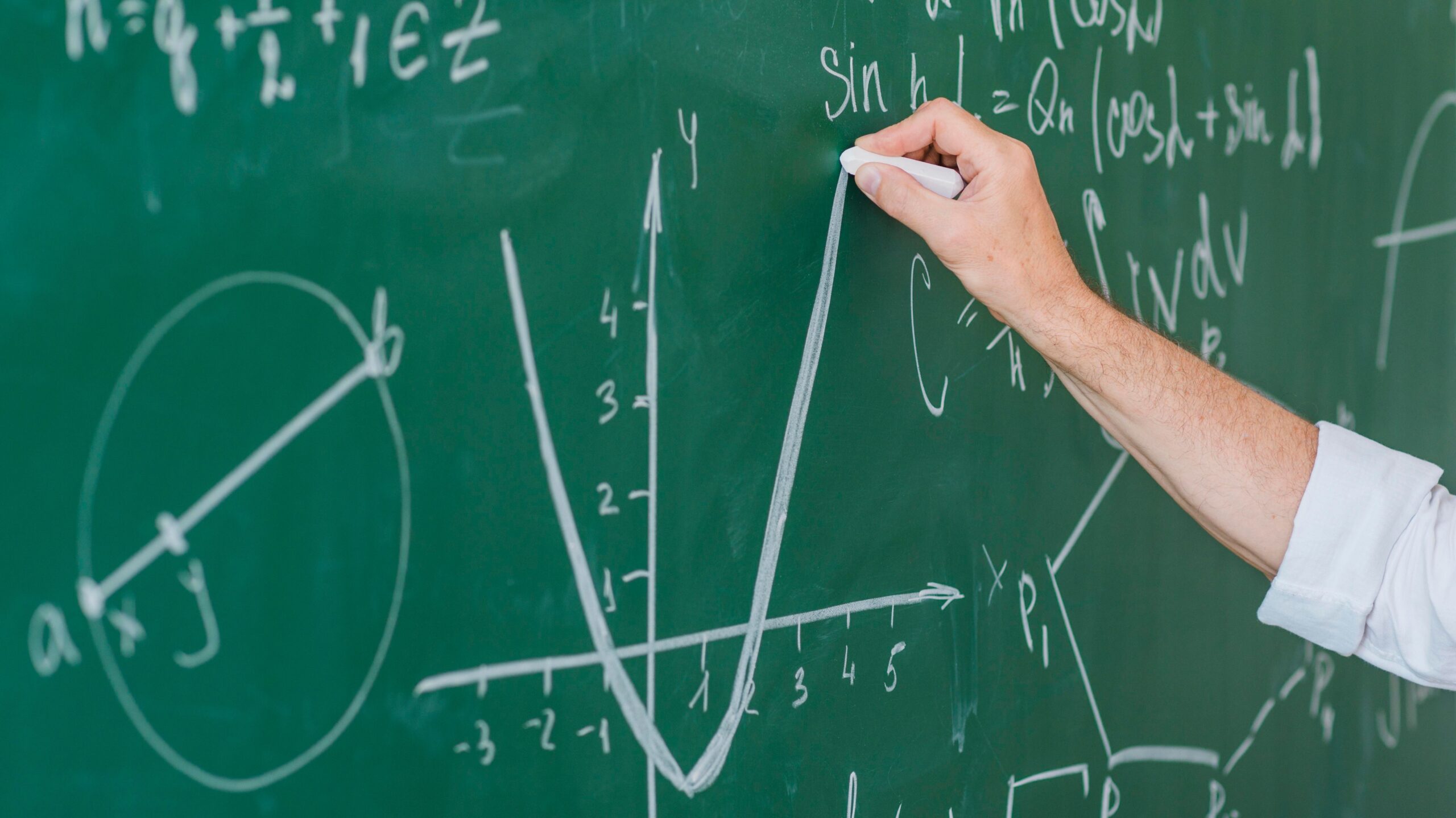 Mann schreibt Mathe-Formel an eine Tafel