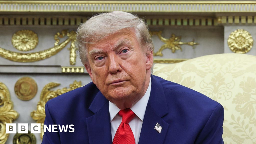 President Donald Trump. He has a serious look on his face and is wearing a blue suit with a white shirt and red tie