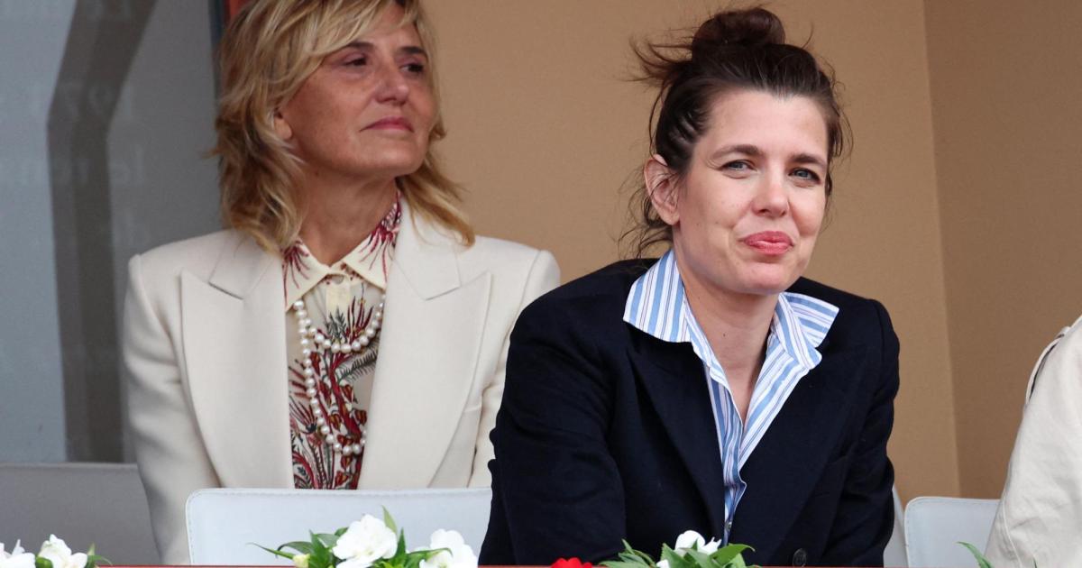 Charlotte Casiraghi sitzt neben einer blonden Frau in einem hellen Blazer vor einem mit Blumen geschmückten Balkongeländer