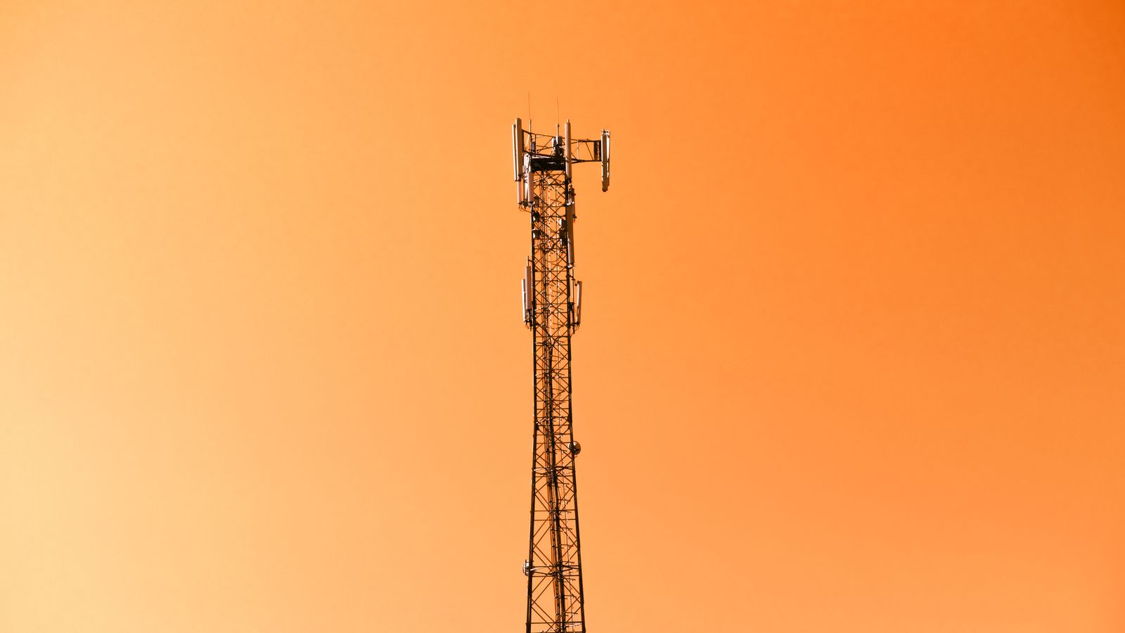 A radio mast silhouetted against a bright sky