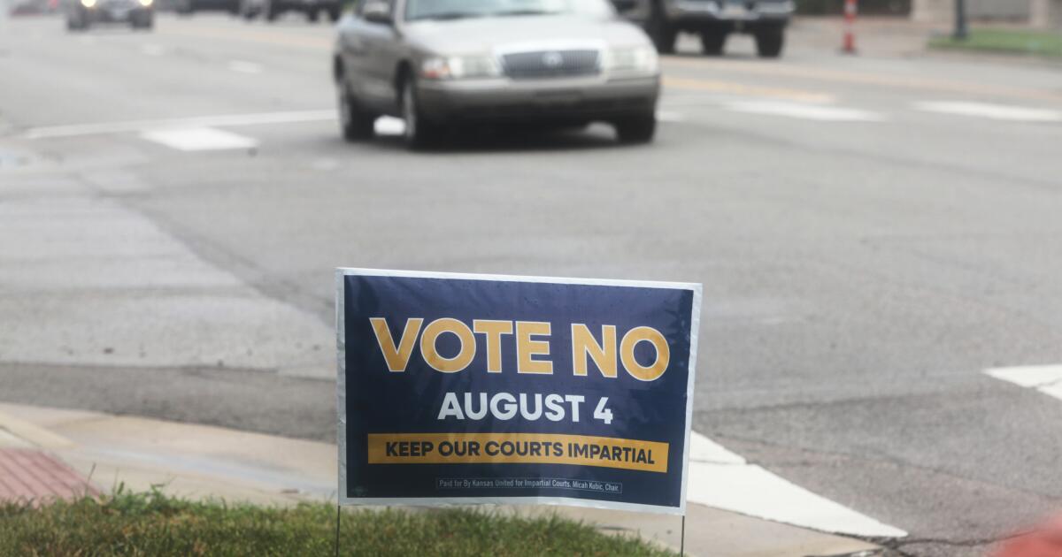 A sign encourages voters to reject a proposal to change how Kanas Supreme Court justices are seated in Topeka, Kan., on