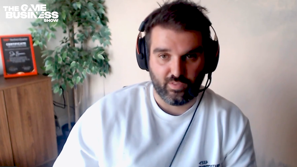 Bulkhead CEO Joe Brammer in a white t-shirt and set of headphones, appearing on The Game Business podcast