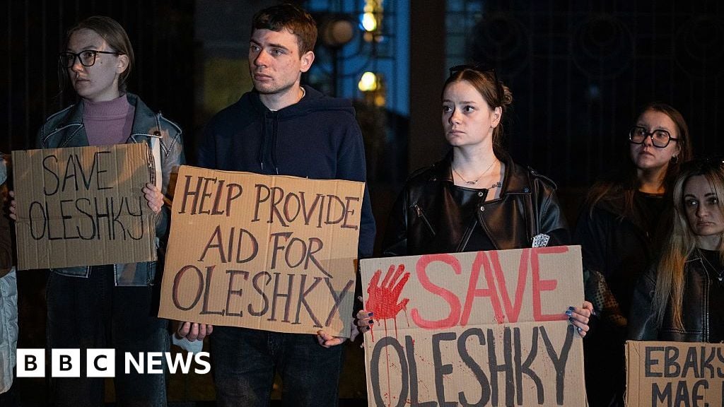 Activists hold placards with slogans during a rally in support of residents of Oleshky, Kherson region, calling on the